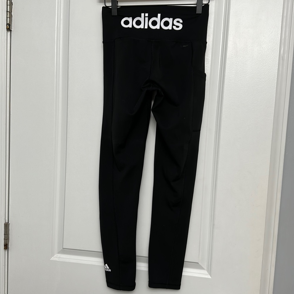 Adidas leggings. ADIDAS spelled out on back of waistband. Logo on left pant leg.